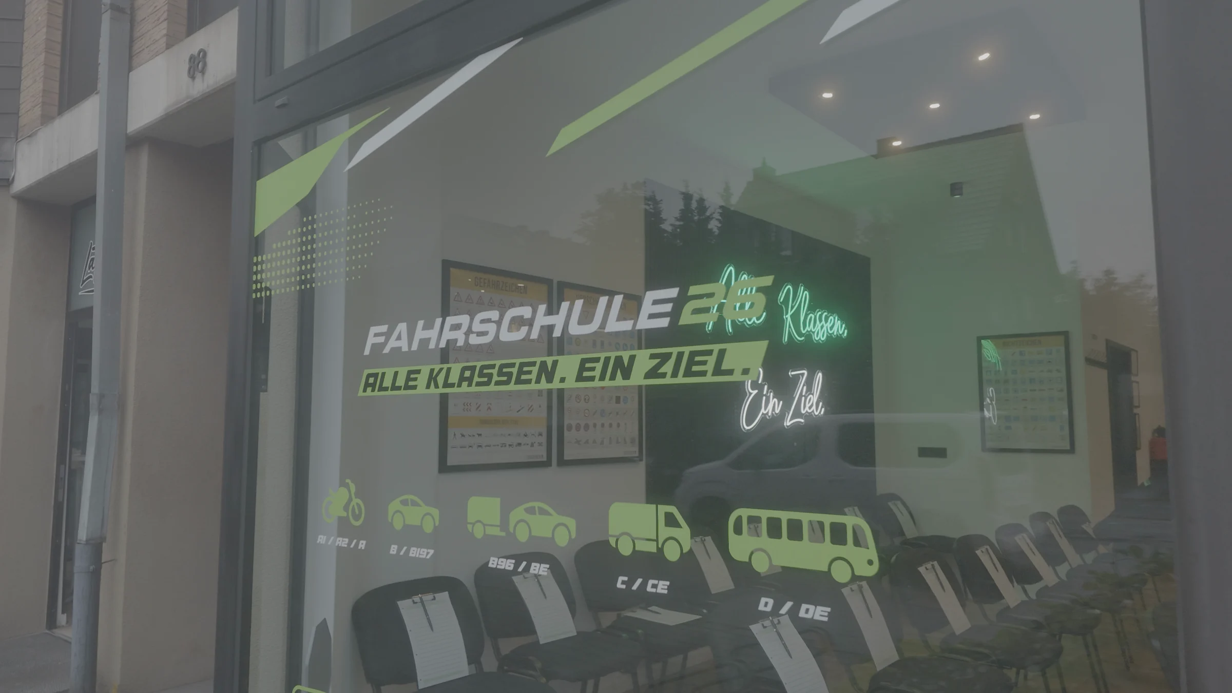 Das Ladenlokal der Fahrschule 26 an der Gerresheimer Straße 88 in Hilden, von der Straße aus durch das beschriftete Schaufenster gesehen.